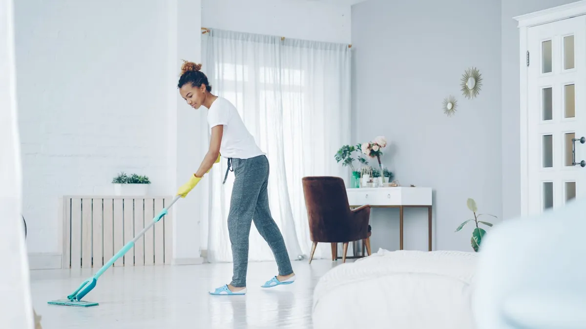 A woman mopping a glossy white floor