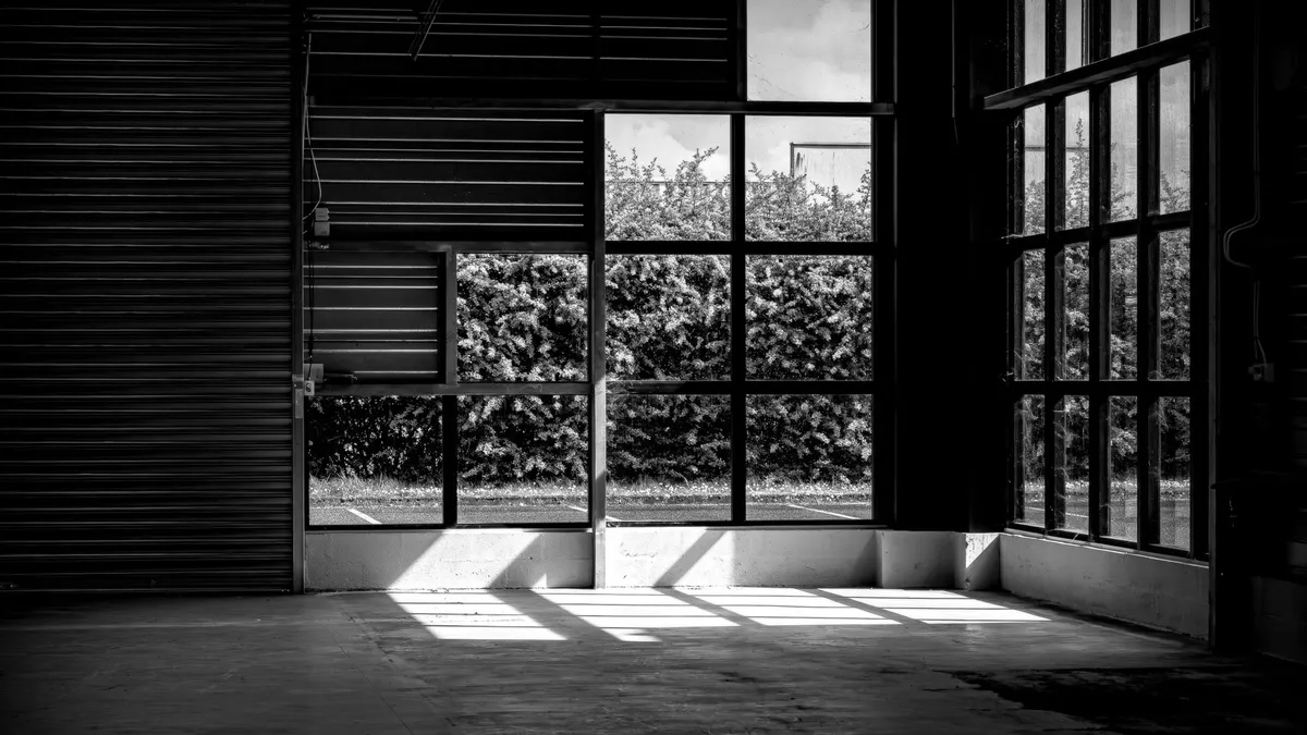 Sunlight falling through large windows onto a concrete floor