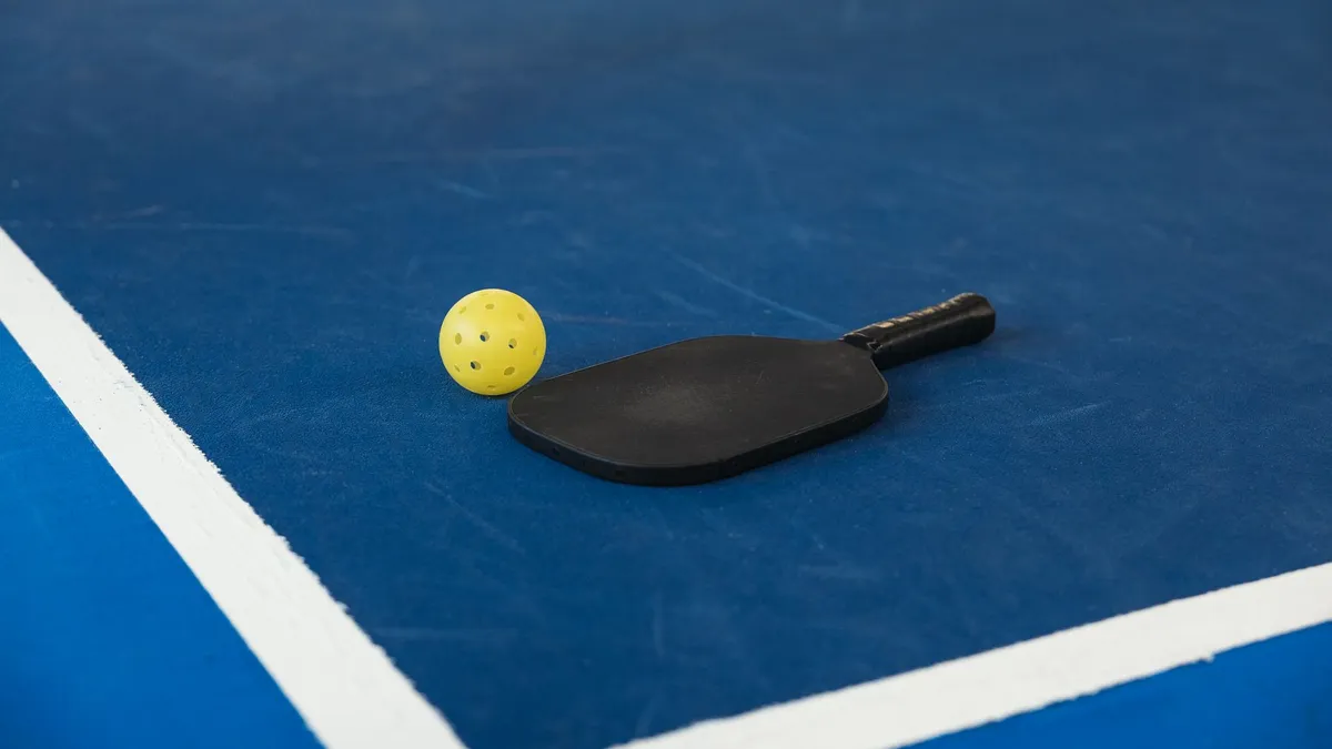 Mavi saha zemininde pickleball raketi ve topu