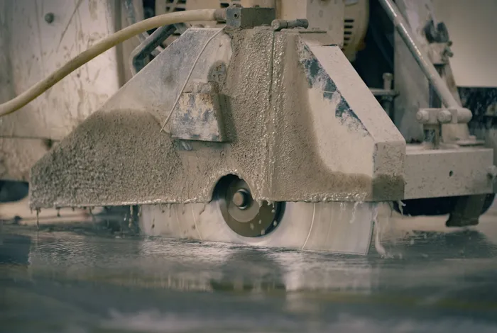 A saw cutting into concrete